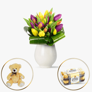 Bouquet of multicolored tulips, candies and teddy bear