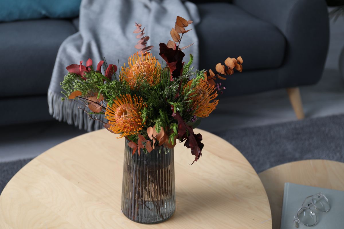 buchet cu flori de Leucospermum in vaza pe o masa de cafea&nbsp;